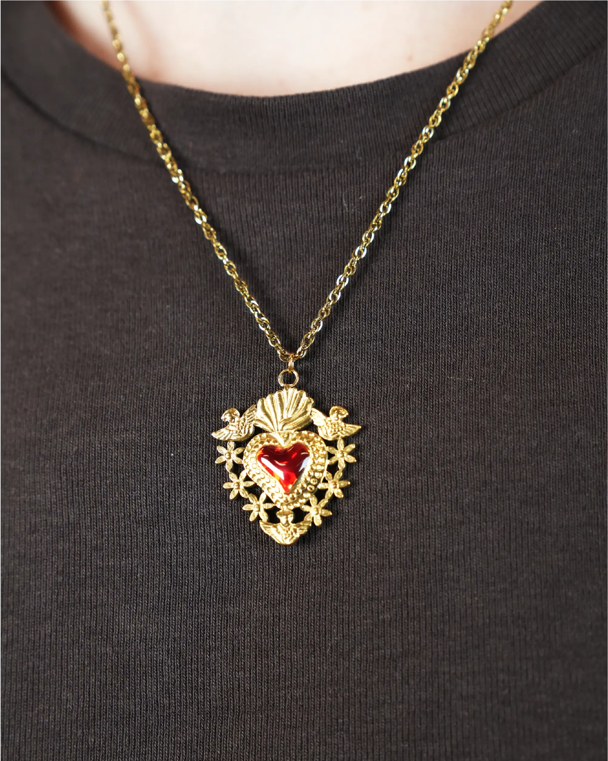 Goudkleurige ketting met een rood hartje met daarom heen bloemen en 2 enegeltjes